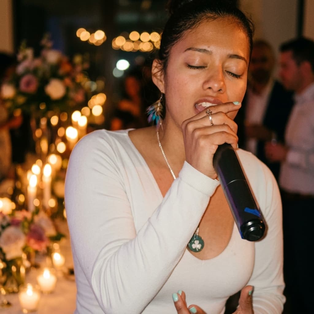Ixchel Dion singing at a candlelit celebration